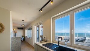 A modern kitchen with a large window, a built-in sink, and a countertop.