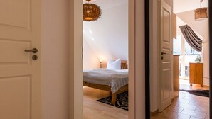A bedroom with a bed, a hanging light fixture, and a view of the outside. - Holiday Apartment in Otseebad Wustrow (Ostseebad Wustrow)