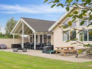 A covered patio area with outdoor furniture and a picnic table.