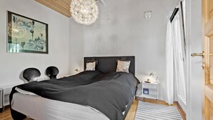 A modern bedroom with a large bed, a unique chandelier, a nightstand, and a painting on the wall. - 2 bedroom beautiful home in Esbjerg V (Esbjerg V)