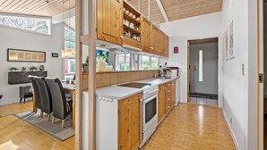 A modern kitchen with wooden cabinets, a built-in oven, and a large window. - 2 bedroom beautiful home in Esbjerg V (Esbjerg V)