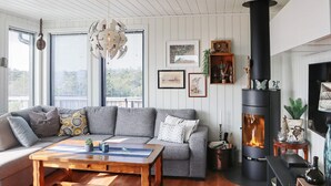 A cozy living room with a grey sofa, wooden coffee table, and a black fireplace.