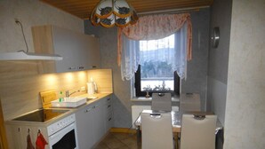 Pieni, käytännöllinen keittiö, jossa on pesuallas, liesi ja ruokailutila.