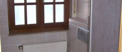 Un baño pequeño con inodoro, ventana y radiador.