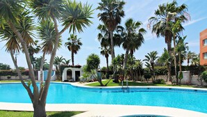 A swimming pool surrounded by palm trees and a small building. - Villa in Spain With Private Pool (Vera)