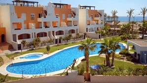 A hotel with a swimming pool, multiple balconies, and a view of the sea. - Villa in Spain With Private Pool (Vera)