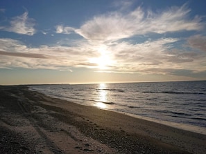 A beach with a clear sky and the sun setting over the horizon. - 7 Person Holiday Home in Fjerritslev (Fjerritslev)