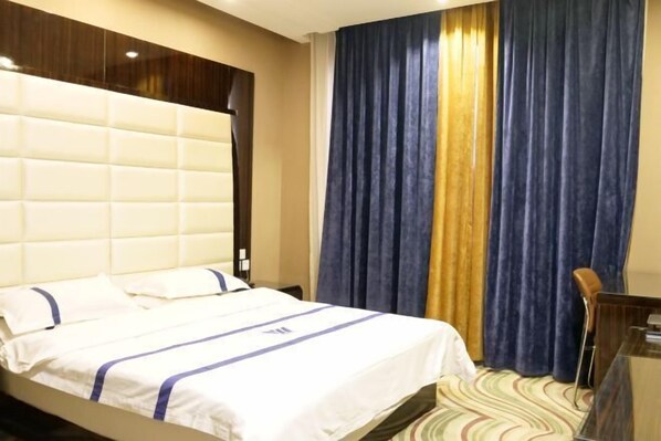 A hotel room with a large bed, a headboard, a desk, and a chair. - Dengkou Youyi Hotel(Dengkou Museum Store) (Dengkou)