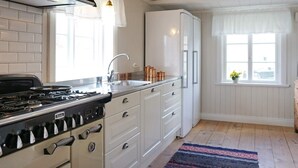 A kitchen with white cabinets, a stove, and a refrigerator. - 6 Person Holiday Home in Hedekas-by Traum (Hedekas)