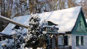 Un edificio coperto di neve con un cartello che recita 'Biergarten'.