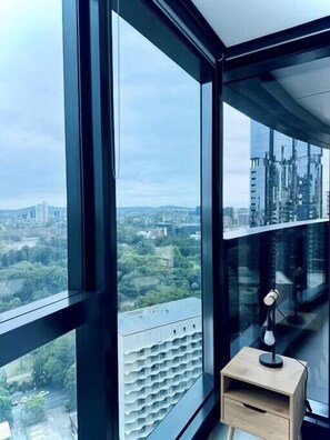 Enjoy a panoramic view of the city and surrounding greenery from the large floor-to-ceiling window.