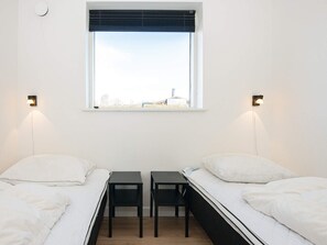 A room with two beds, a window with blinds, and two wall-mounted lamps. - 4 Star Holiday Home in Borkop (Borkop)