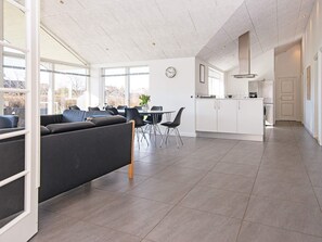 A modern interior with a dining area, kitchen, and seating space.