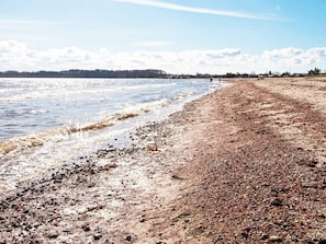 A beach with a pebbly shore and calm water. - 4 Star Holiday Home in Borkop (Borkop)