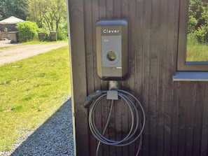 A Clever electric vehicle charging station mounted on a wooden wall with a hose connected to it. - 4 Star Holiday Home in Glesborg (Glesborg)
