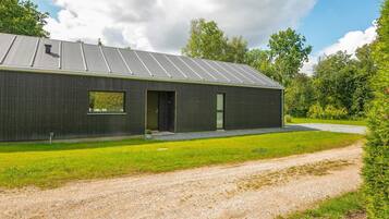 A modern building with a metal roof, a small window, and a door.