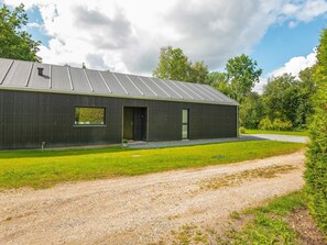 A modern building with a metal roof, a small window, and a door.
