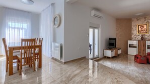 Un salon moderne comprenant un coin repas, un téléviseur et un radiateur.