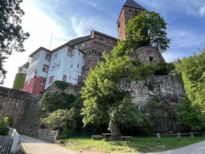A historic castle with a prominent tower, a white building with red accents, and lush greenery surrounding the site. - Holiday Apartment Schlossblick 2 (Zwingenberg)