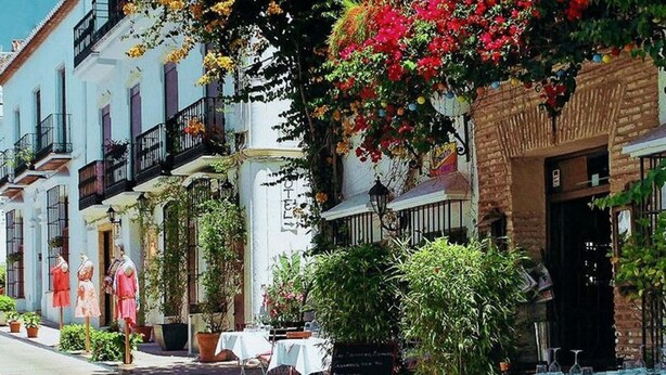 A hotel with outdoor seating, balconies with plants, and a sign reading "HOTEL". - Belvilla by OYO Apartamento Port Avenue (Marbella)