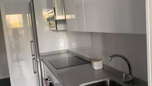 A modern kitchen with stainless steel appliances, a built-in oven, and a sink. - Belvilla by OYO Apartamento Port Avenue (Marbella)