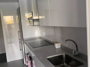 A modern kitchen with stainless steel appliances, a built-in oven, and a sink. - Belvilla by OYO Apartamento Port Avenue (Marbella)