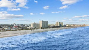 A coastal cityscape with beachfront hotels, a water tower, and a sandy beach. - Luxury Oceanfront 3Bedroom Paradise (North Myrtle Beach)