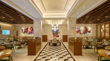 A spacious lobby with a checkered floor, modern furniture, and decorative wall art.