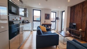 Ein modernes Wohnzimmer mit einer Couch, einem Couchtisch, einem Fernseher und einer Holzwand.