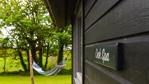 Un edificio de madera con un letrero que dice "Oak Spa" y una hamaca colgada del techo.