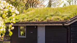 A small cabin with a green roof, a door, and a window. - Lodge 4 Hot Tub by Interhome (Launceston)