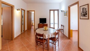 A dining area with a round table, chairs, a television, and a framed picture on the wall. - Belvilla by OYO Casa Castiglia (Polino)