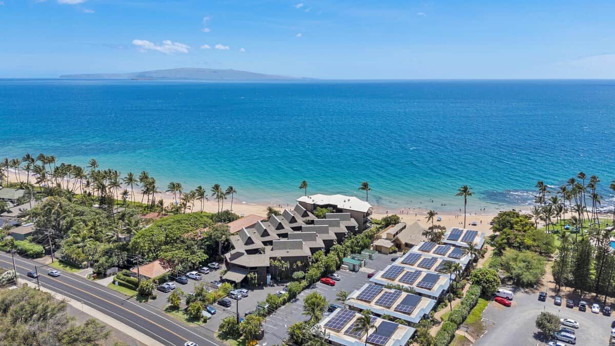 Eine Küstenimmobilie mit Parkplatz, Solaranlage und Blick auf den Strand.