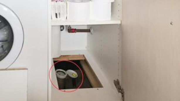 A laundry room with a washing machine, a shelf with various items, and a cabinet with a drawer containing two containers. - 9 Person Holiday Home in Harboore (Harboore)