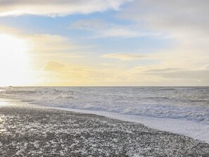 A beach with waves and a clear sky.