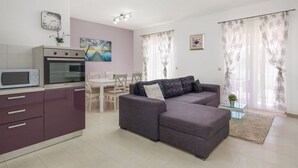 Un appartement moderne comprenant un coin cuisine, un espace repas, un canapé et un salon.