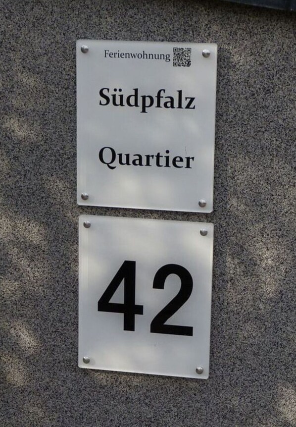 Two signs mounted on a wall: one reads "Südpfalz Quartier" and the other displays the number "42".