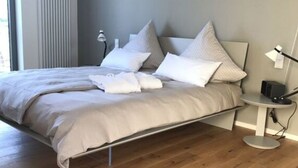A modern bedroom with a bed, bedside table, lamp, and a radiator.