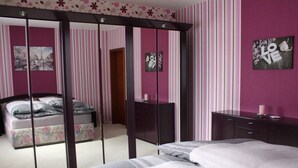 A bedroom with a bed, a dresser, and a wardrobe with a mirror. - Uitzicht op Droomlocatie (Annaberg-Buchholz)
