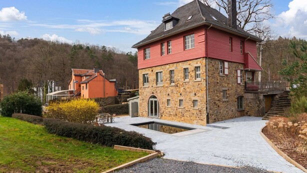 A two-story stone house with a red roof and a small balcony. - Luxury Chalet in Jalhay With Private Sauna (Jalhay)