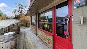 A building with a red door, a wooden deck, and a view of the street. - Luxury Chalet in Jalhay With Private Sauna (Jalhay)