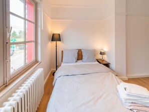 A bedroom with a bed, two bedside lamps, a window with a view of the outside, and a radiator. - Luxury Chalet in Jalhay With Private Sauna (Jalhay)