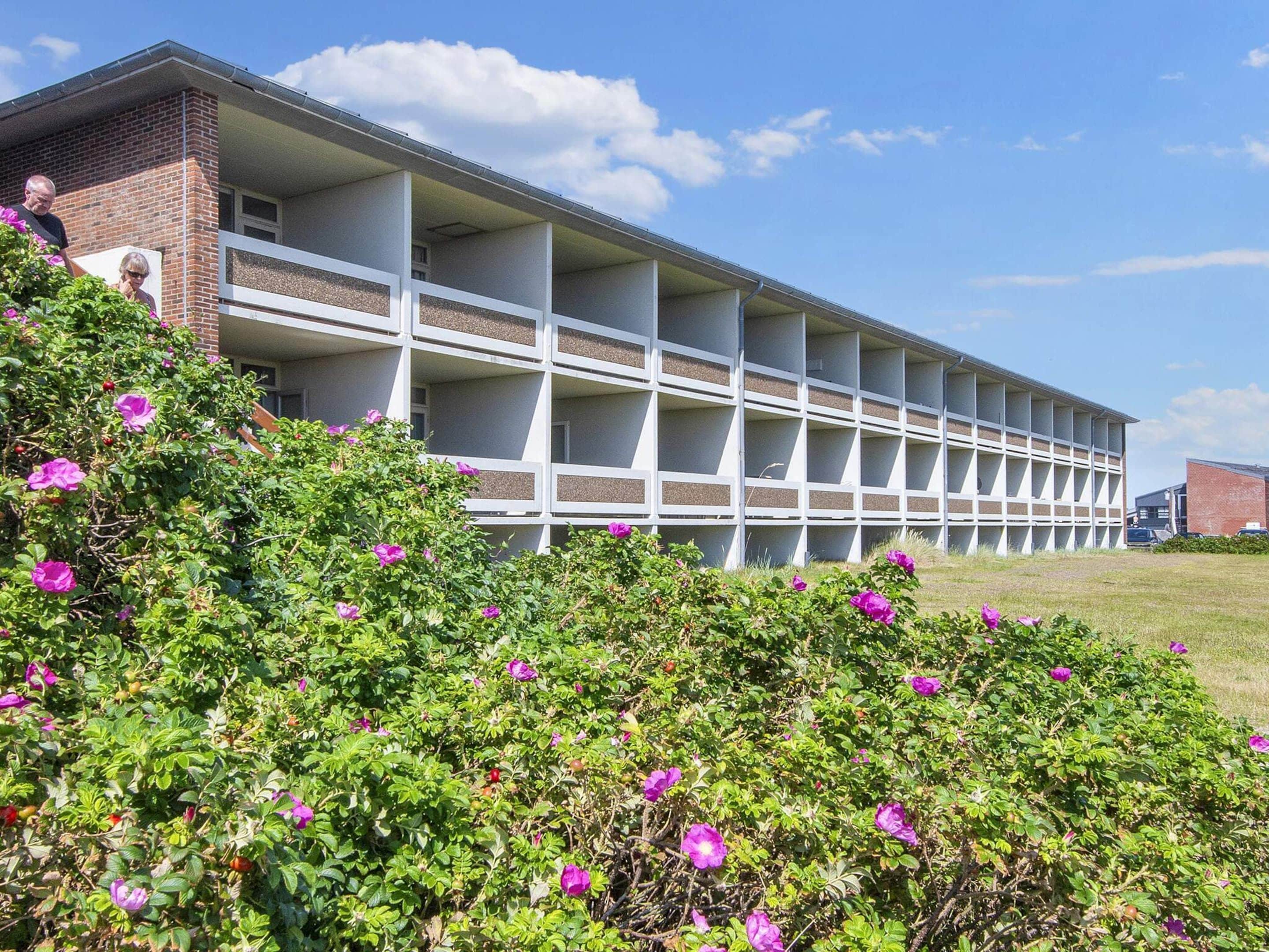 A multi-story building with a brick facade and a series of balconies.