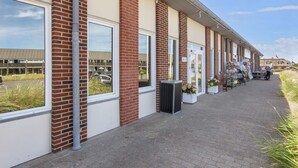 En rad låga byggnader med fasader av tegel och stora fönster, troligen en del av ett större affärs- eller kontorskomplex.