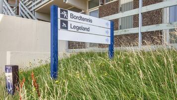 A directional sign with arrows pointing towards 'Bordtennis' and 'Legeland'.