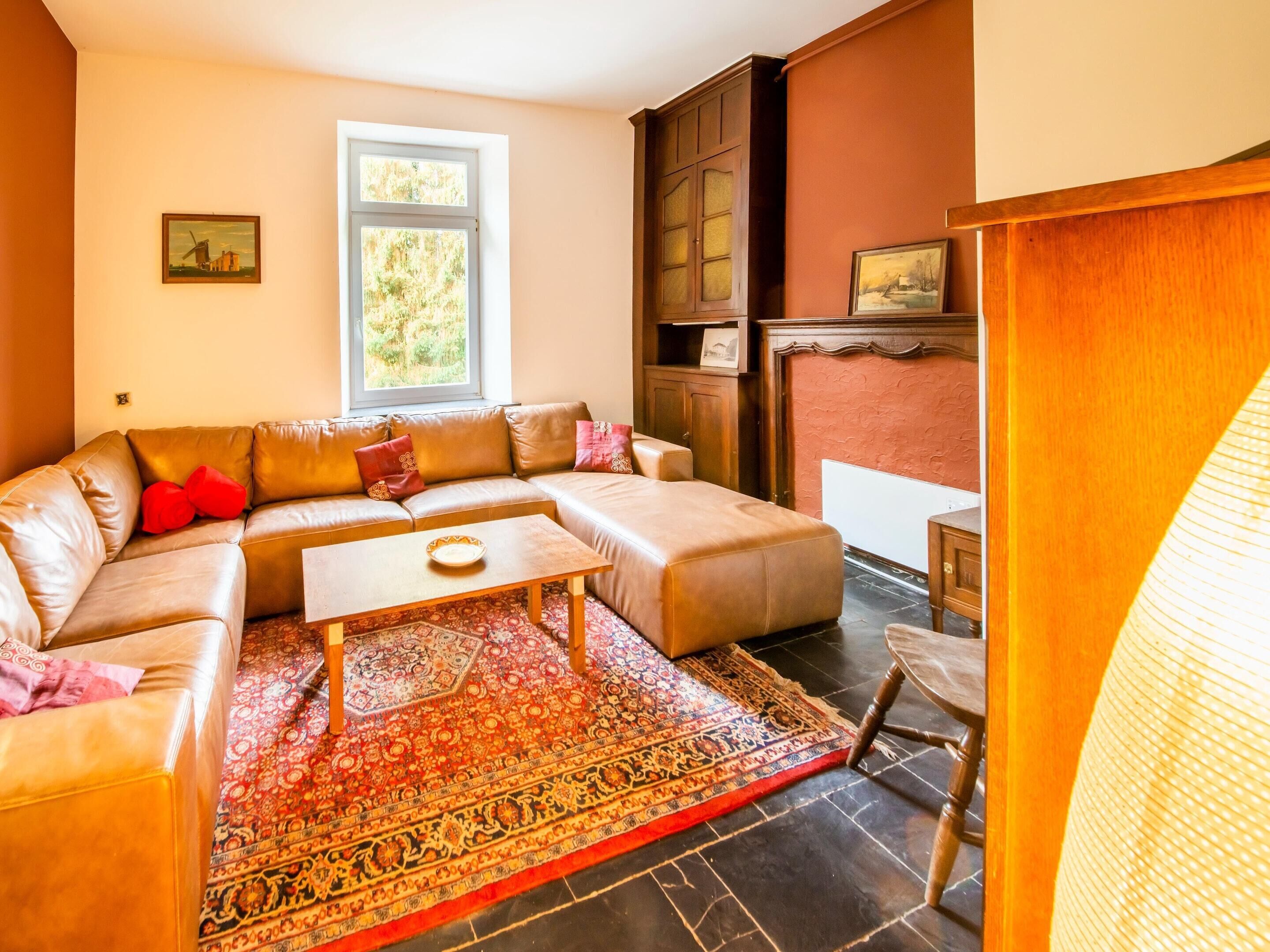 Un salon avec un canapé d’angle beige, une table basse et un tapis à motifs.