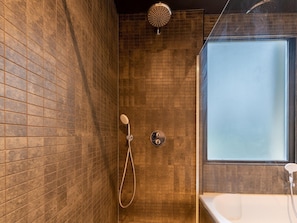A bathroom with a shower, a bathtub, and a window. - Holiday Home in Zevenhuizen With Roofed Swim Pool (Zevenhuizen)