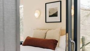 A bedroom with a bed, pillows, a framed picture on the wall, and a window. - Waterview. Hot Tub. Gas Firepit. Lancaster 40 min. (Airville)