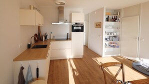 A compact kitchen with a built-in oven, a sink, and a wooden countertop. - Sunny Apartment Directly on the Heegermeer (Heeg)