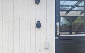 A building with a white exterior, a black door, and a small window.